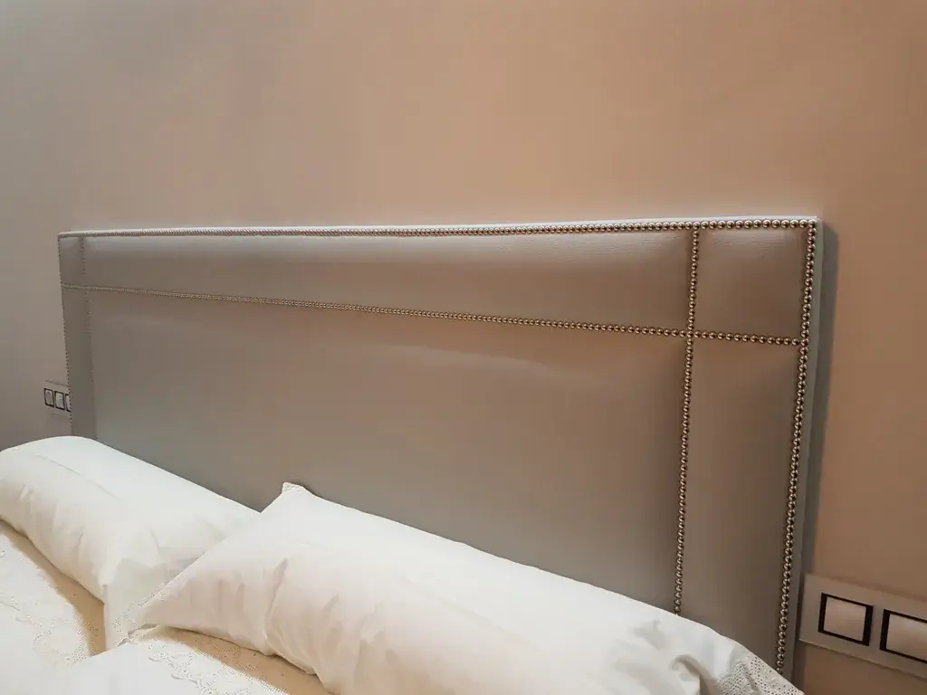 Cabecero polipiel beige con tachuelas y costuras decorativas
