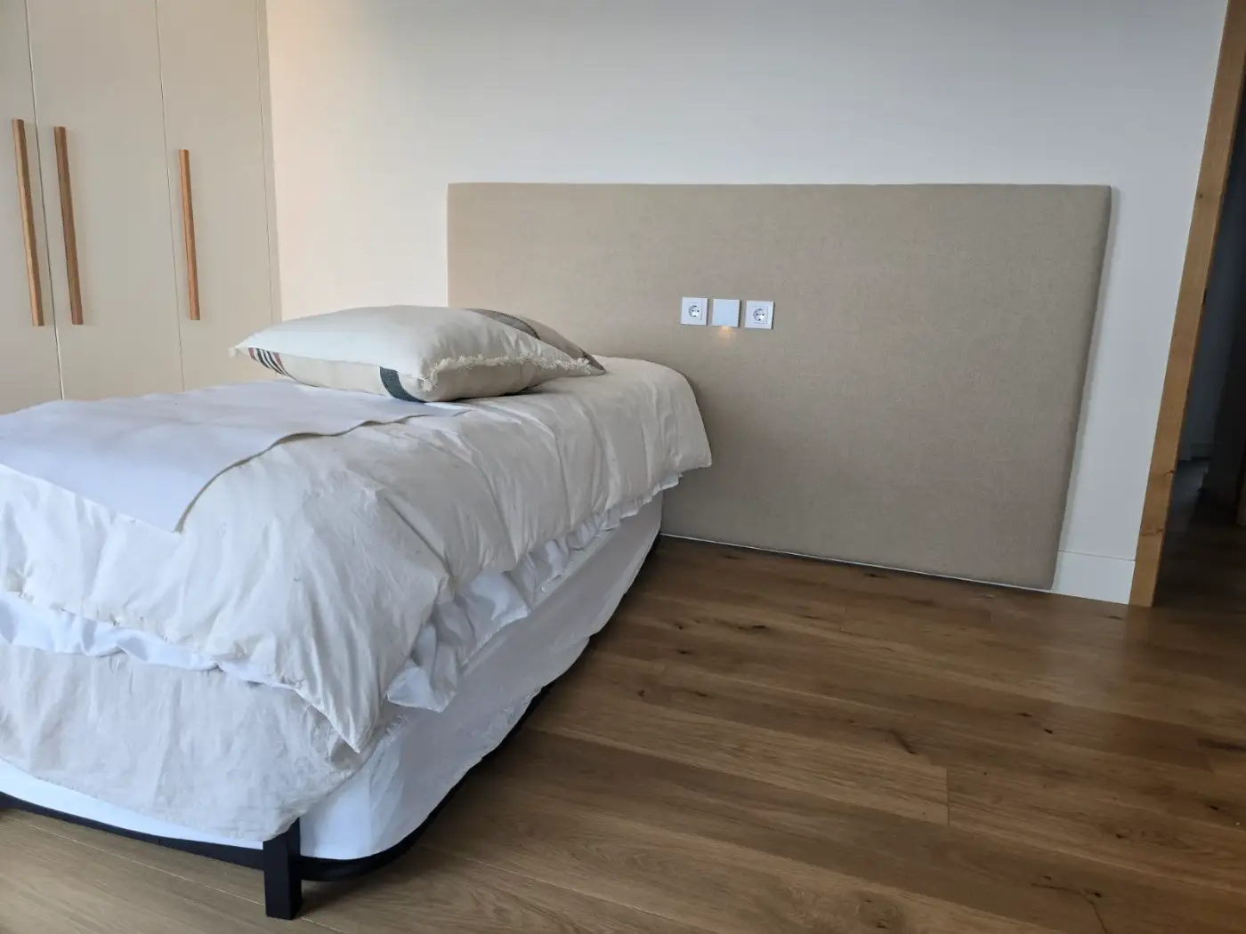Cabecero liso tapizado en lino beige en dormitorio moderno