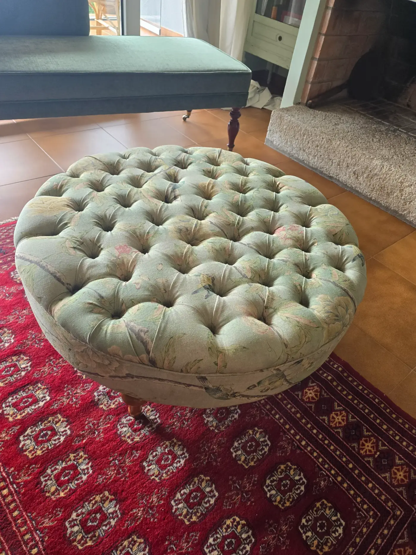 Pouf redondo tapizado en capitoné con tela floral verde
