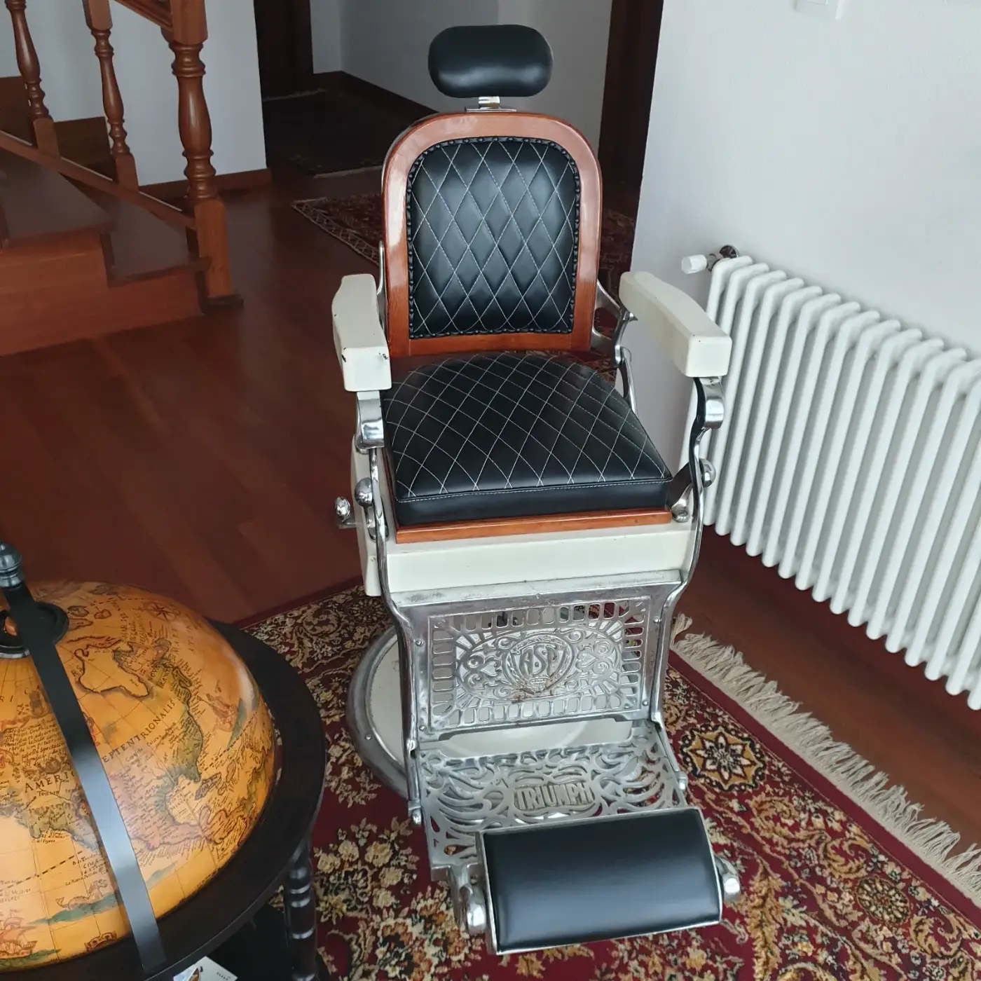 Sillón de barbero antiguo restaurado tapizado en piel negra con capitoné