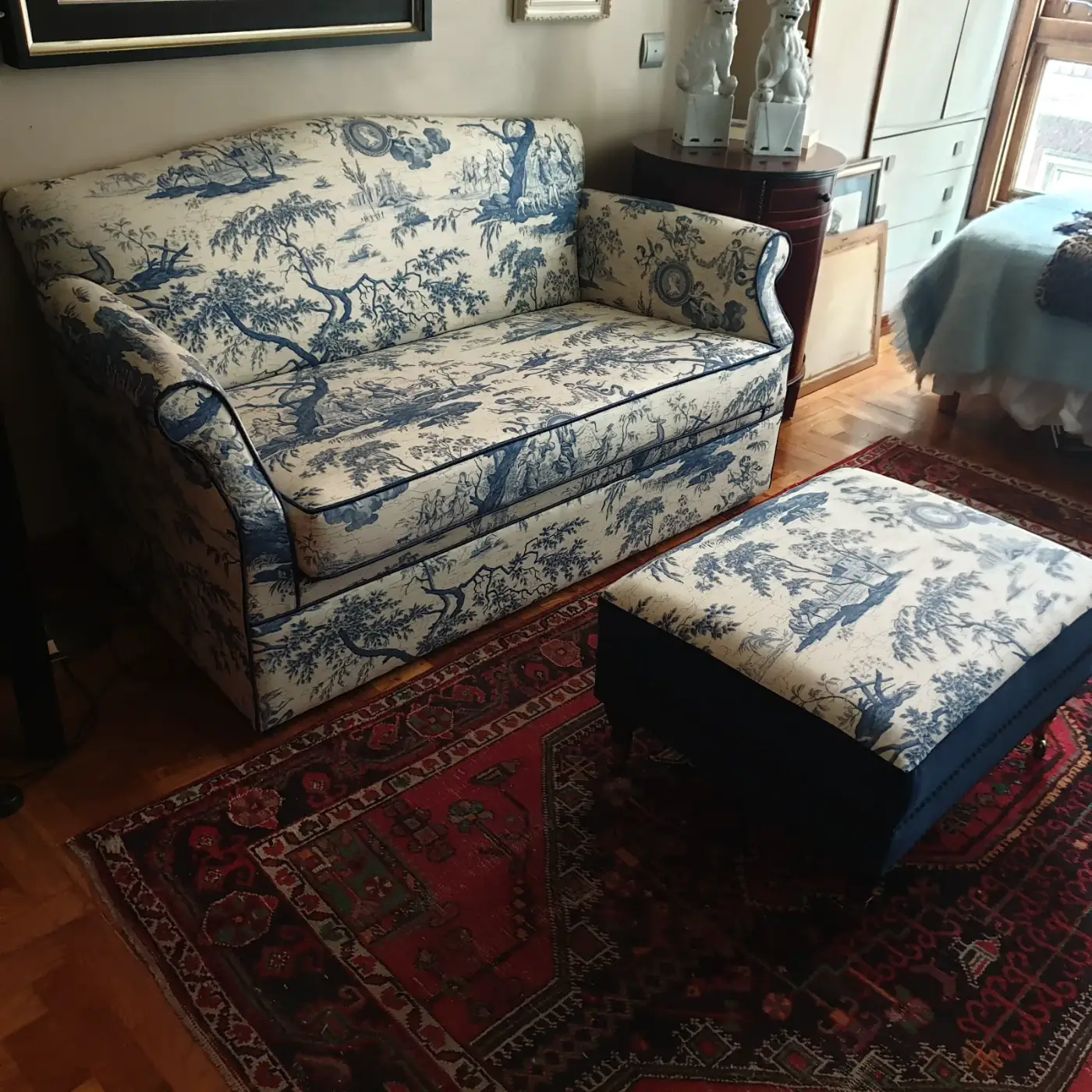 Sofá clásico tapizado en toile de jouy azul con otomana