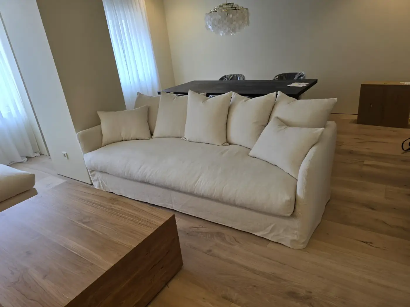 Sofá de lino crema con cojines en salón moderno