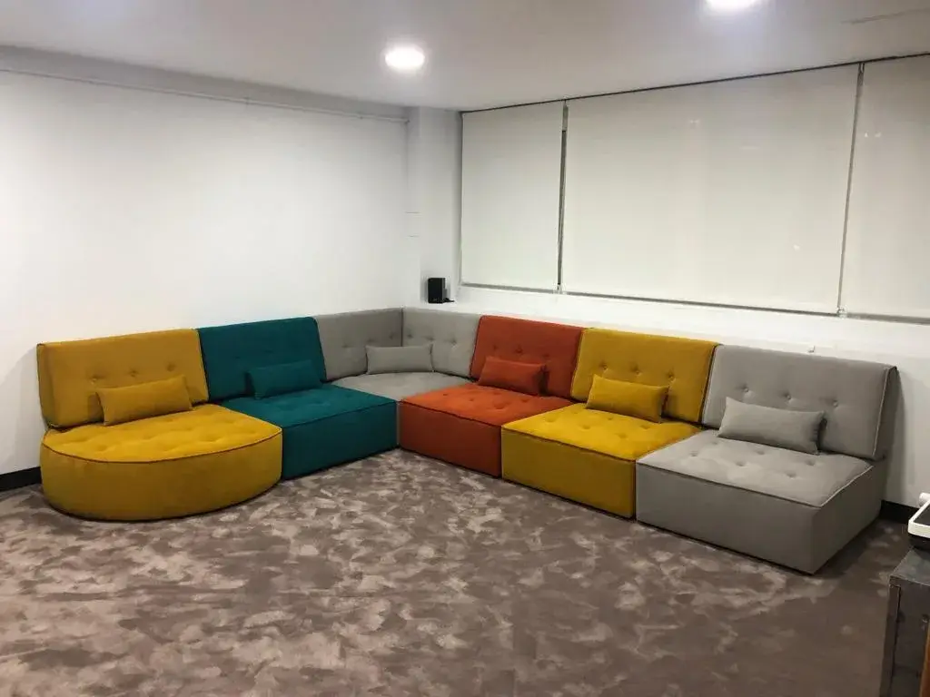 Sofá modular multicolor con módulos amarillos, grises, azules y naranjas